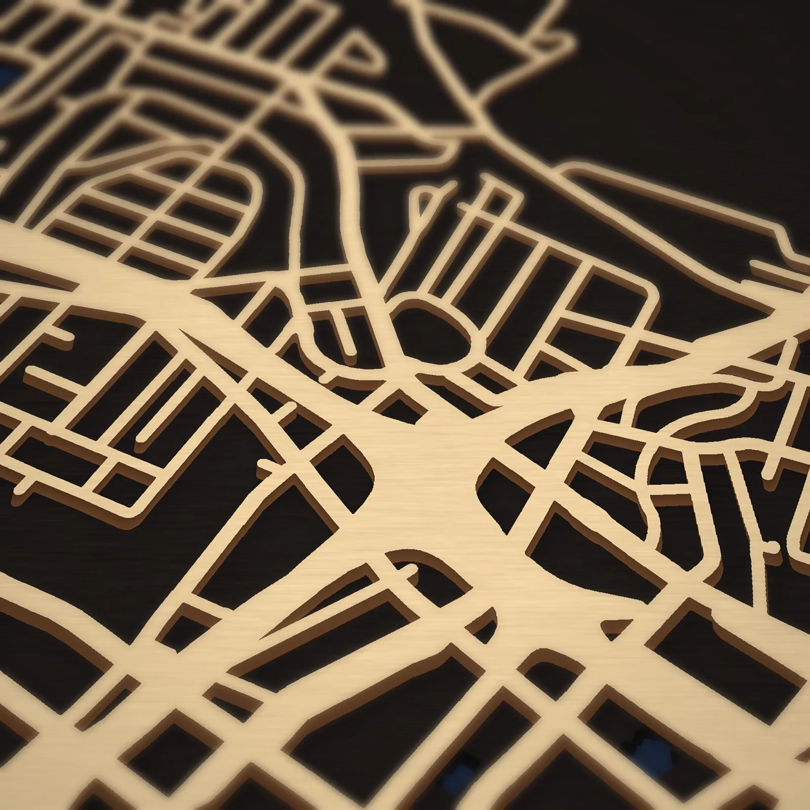 Close-up of the Los Angeles map's three laser-cut layers: birch streets over black land and navy water