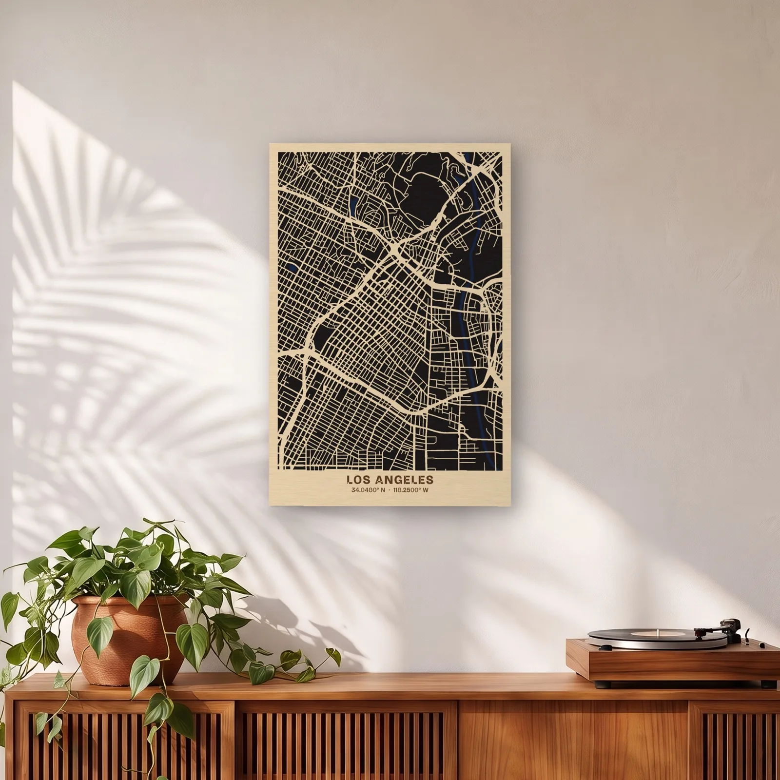 Los Angeles layered wood map, 12 x 18 in, on a sunlit wall above a teak credenza
